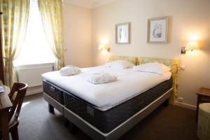 a hotel room with a bed with towels on it at L'Univers Arras by Elema Hotels ex Hôtel de l'Univers Arras in Arras