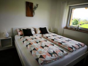 a bed with a quilt on it in a bedroom at Ferienwohnung im Panoramaweg in Rieden