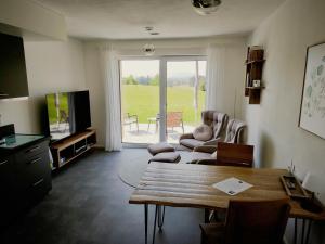 a living room with a table and chairs and a television at Ferienwohnung im Panoramaweg in Rieden
