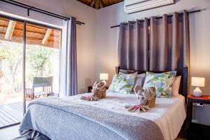 a bedroom with a bed with two teddy bears on it at Lions Place in Grietjie Game Reserve