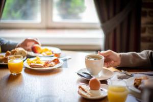 two people sitting at a table with eggs and coffee at L'Univers Arras by Elema Hotels ex Hôtel de l'Univers Arras in Arras +61 photos