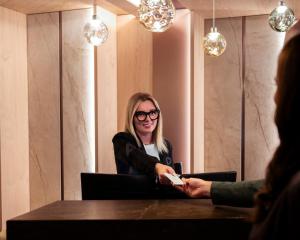 a woman sitting at a table talking to a person at Hotel Paganella Andalo in Andalo