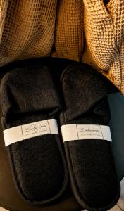 a pair of black slippers with tags on them at Maison LOVEROOM 70m2 L'entre Nous in Grenoble +21 photos