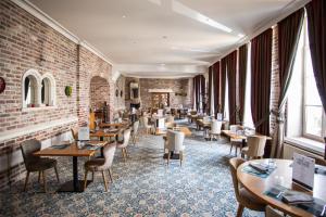 a restaurant with tables and chairs and a brick wall at L'Univers Arras by Elema Hotels ex Hôtel de l'Univers Arras in Arras