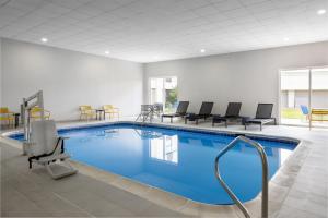 a pool in a hotel room with chairs and tables at Hampton Inn Terre Haute in Terre Haute