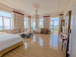 a bedroom with a bed and a living room with windows at AN Apartment in Danang