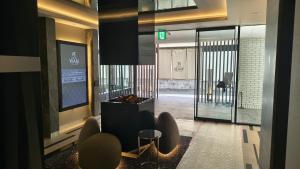 a lobby with a waiting area with chairs and a glass door at ホテル侘 in Himeji +22 photos