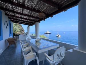 a table and chairs on a balcony with the ocean at Le casette di nonna Giulia B in Lingua