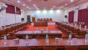 a conference hall with tables and chairs and water bottles at Batika Resort Sauraha in Sauraha