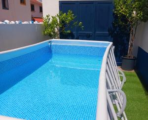 a swimming pool with a chair next to a house at Casa de Sume in Monte da Pedra