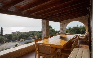 a wooden table on a balcony with a view of the ocean at Pirgos Petropoulea in Poliána