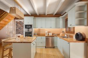 a kitchen with white cabinets and a counter top at Pirgos Petropoulea in Poliána +65 photos