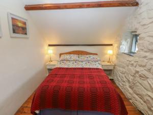 a bedroom with a bed with a red blanket at Penfeidr Newydd in Newport