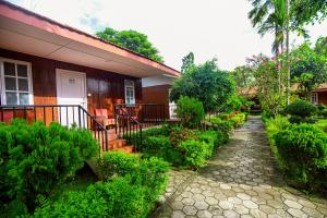 a house with a stone walkway leading to a garden at Batika Resort Sauraha in Sauraha