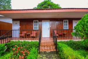 a house with a porch with tables and chairs at Batika Resort Sauraha in Sauraha