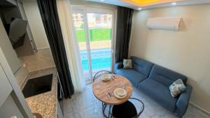 a living room with a blue couch and a table at Hillfort Suites Apart Otel in Demre