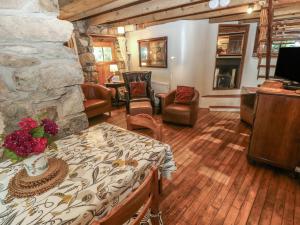 a living room with a stone fireplace and a table at Penfeidr Newydd in Newport