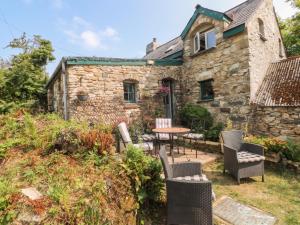 an old stone house with a table and chairs at Penfeidr Newydd in Newport