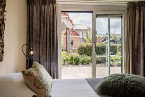 a bedroom with a large window with a view of a yard at Hotel De Walvisvaarder in Lies +118 photos