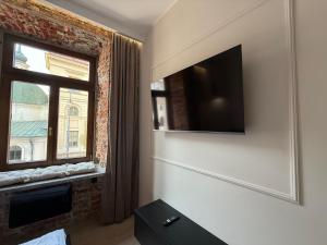 a living room with a television and a window at GRATIA RESIDENCE Lublin in Lublin