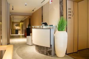 a large white vase with a plant in a hallway at Ala Boutique Hotel in Almaty