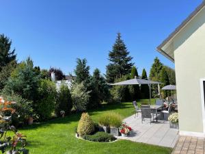 eine Terrasse mit Tisch und Sonnenschirm im Garten in der Unterkunft Bernhards in Buch