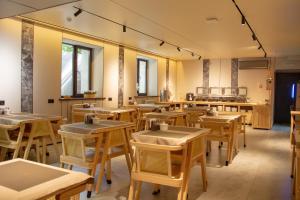 an empty restaurant with wooden tables and chairs at Ala Boutique Hotel in Almaty