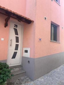 a door on the side of a pink building at Casa do Evaristo in Nabais