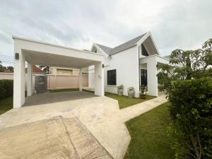 a white house with a large yard at Indigo Garden Villa by Somjai in Ban Tha Fat