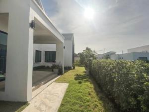 a white house with a fence next to a yard at Indigo Garden Villa by Somjai in Ban Tha Fat +10 photos
