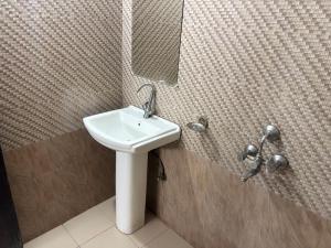 a bathroom with a sink and a mirror on the wall at Grand Almada Inn in Lucknow