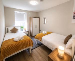 a bedroom with two beds with towels on them at The Viking Townhouse - Heart of Waterford in Waterford