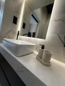 a bathroom with a white sink and a mirror at GRATIA RESIDENCE Lublin in Lublin +33 photos
