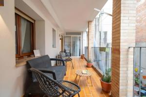 a balcony with chairs and tables on a building at Can Jeroni in Figueres