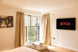 a bedroom with a bed and a window with a television at Luxury Flat close to City Centre & Docks in Southampton