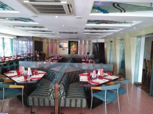 a dining room with a long table and chairs at Privilege Inn in Mumbai