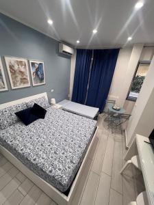 a bedroom with two beds and a blue wall at B&B VMHome in Torre del Greco
