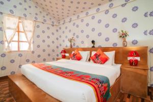 a bedroom with a large white bed with red pillows at Chokhi Dhani Desert Camp in Sām