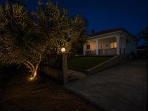 a house with a fence and a tree in front of it at My House in Paralia Messi in Aroyí
