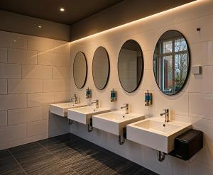 a bathroom with three sinks and three mirrors at Space Hotel KL Sentral in Kuala Lumpur +28 photos