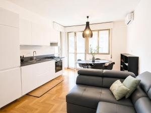 a kitchen and living room with a couch and a table at The Charme - Modern Apartment in Como with Balcony in Como