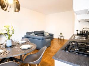 a kitchen and living room with a couch and a table at The Charme - Modern Apartment in Como with Balcony in Como +18 photos