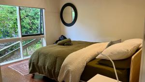 a bedroom with a bed with a mirror on the wall at The Bluff Shack in Wye River