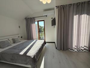 a bedroom with a bed and a large window at Alpine in Skhidnitsa