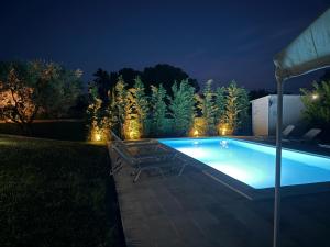a swimming pool in a yard at night at My House in Paralia Messi in Aroyí