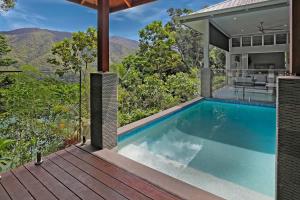 an infinity pool on the deck of a house at Rainforest Retreat - Pool W Stunning Views in Redlynch