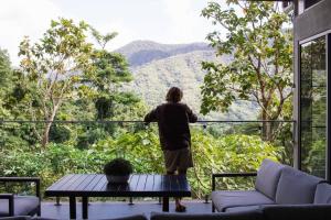 a person looking out of a window at the mountains at Rainforest Retreat - Pool W Stunning Views in Redlynch
