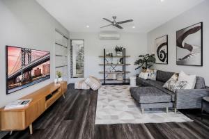 a living room with a couch and a tv at Rainforest Retreat - Pool W Stunning Views in Redlynch