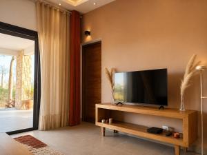 a living room with a flat screen tv on a wall at Le havre des palmiers in Tsivonoabe