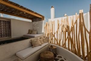 a balcony with a couch and a wooden fence at Maria's place boutique hotel in Antiparos